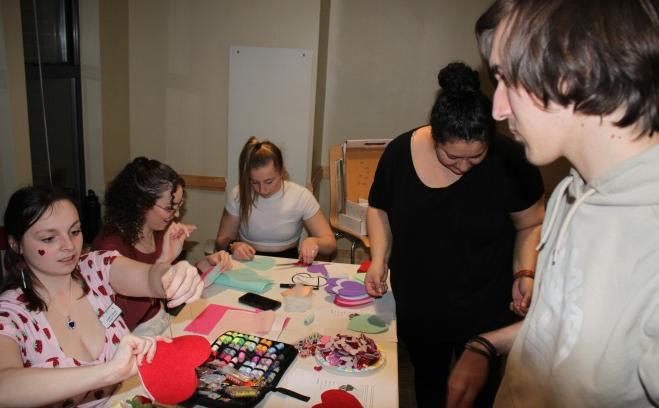 Students making heart crafts in lounge of resident hall
